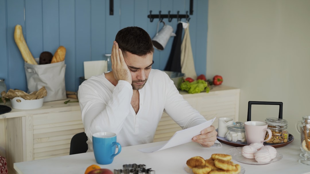 Person reviewing debt settlement paperwork at kitchen table