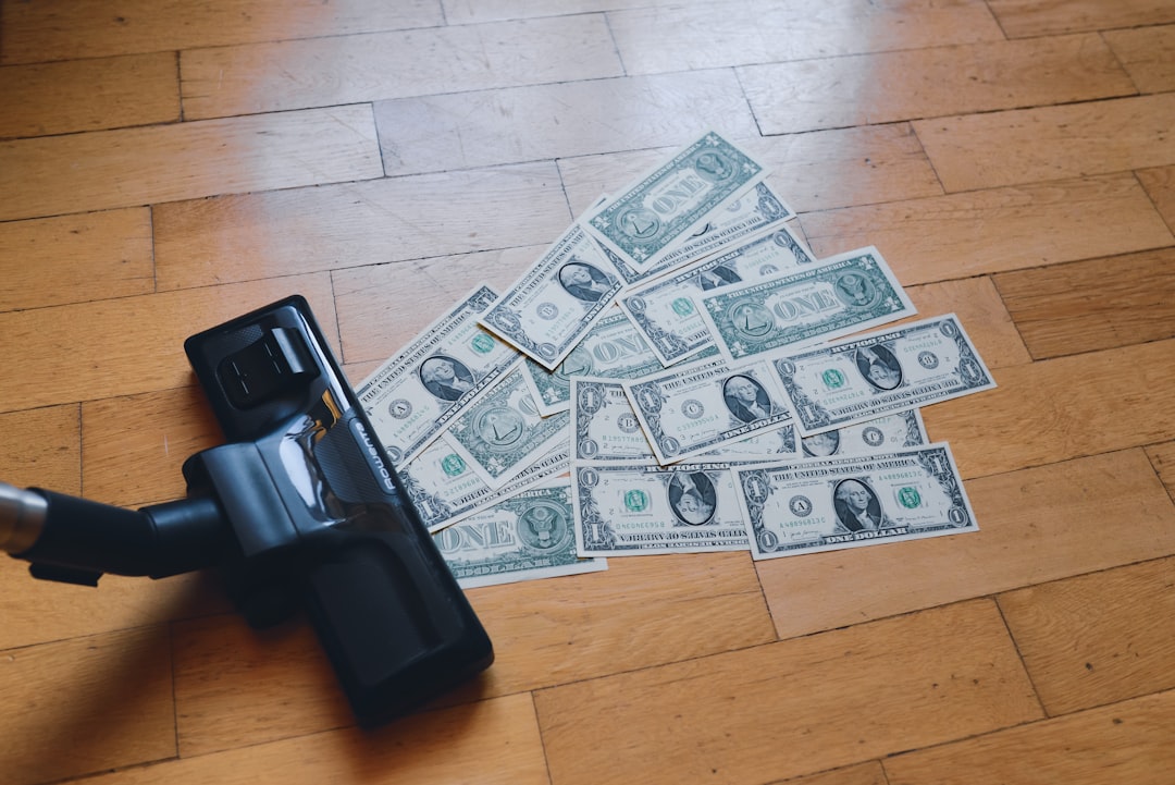 a pile of money being vacuumed by debt
